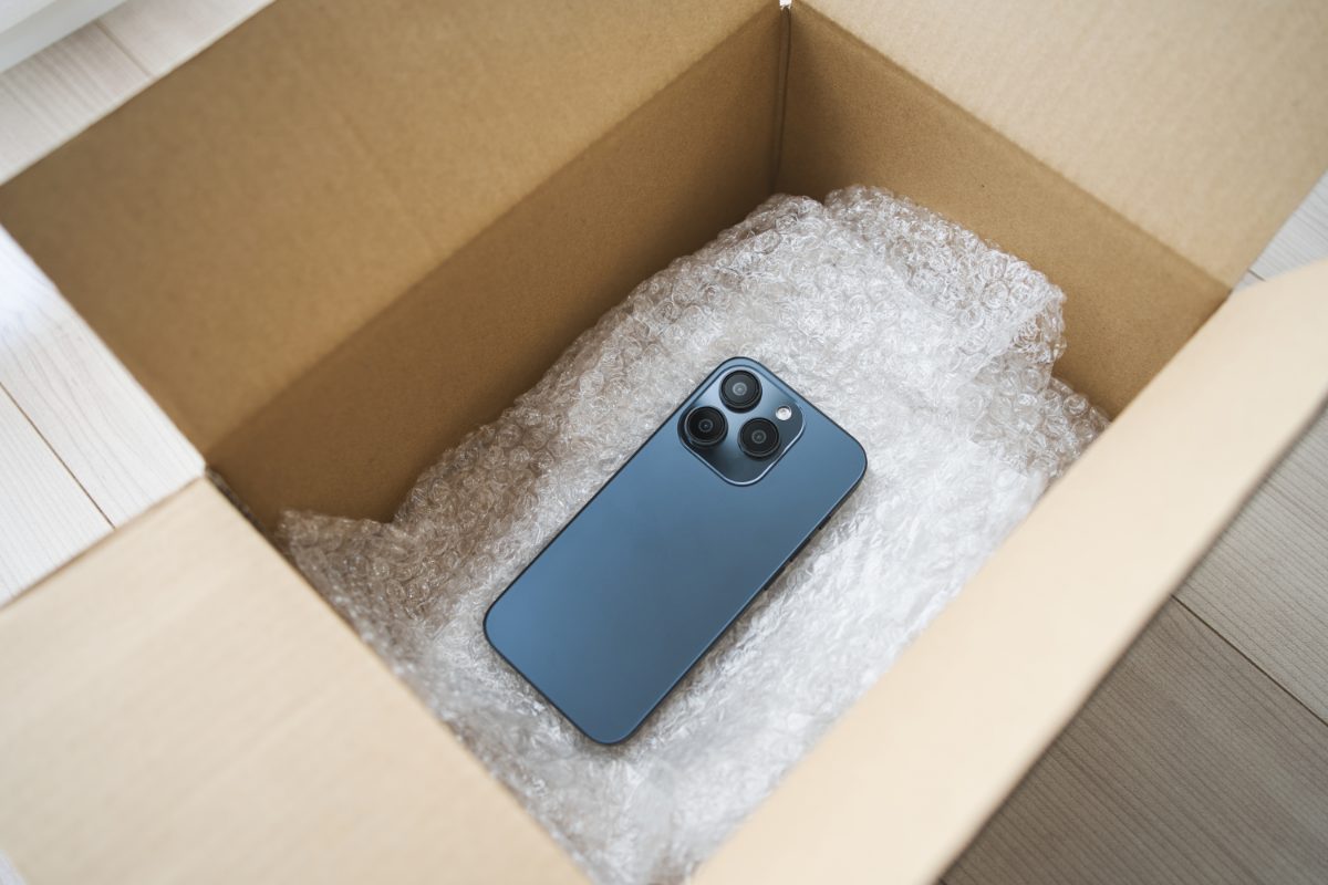緩衝材を入れた段ボール箱にスマートフォンを梱包した様子(イメージ)
