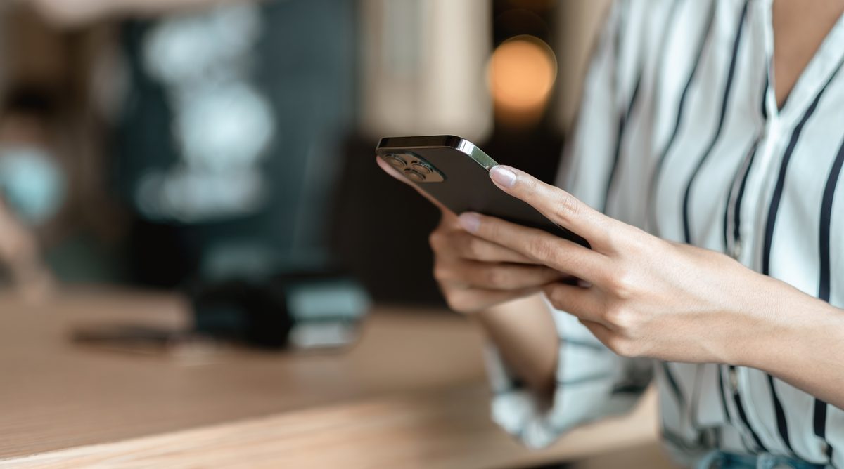 手放すスマートフォン（iPhone）を手に持つイメージ